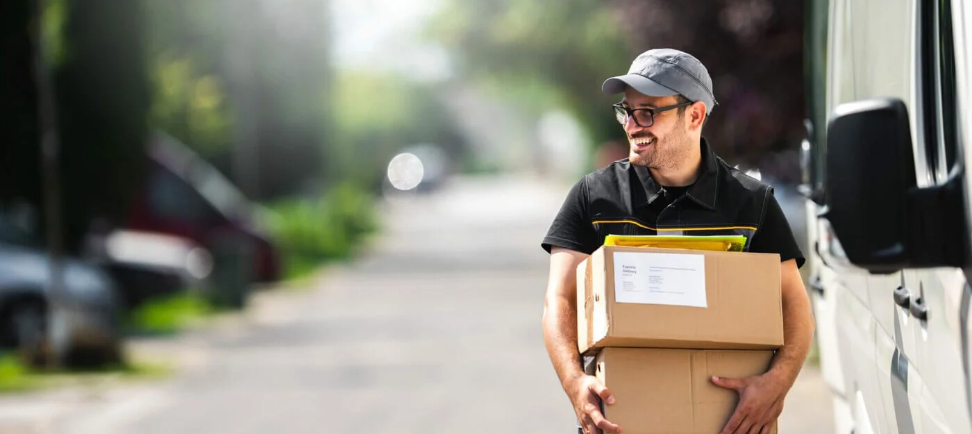 A delivery person carrying two moving boxes