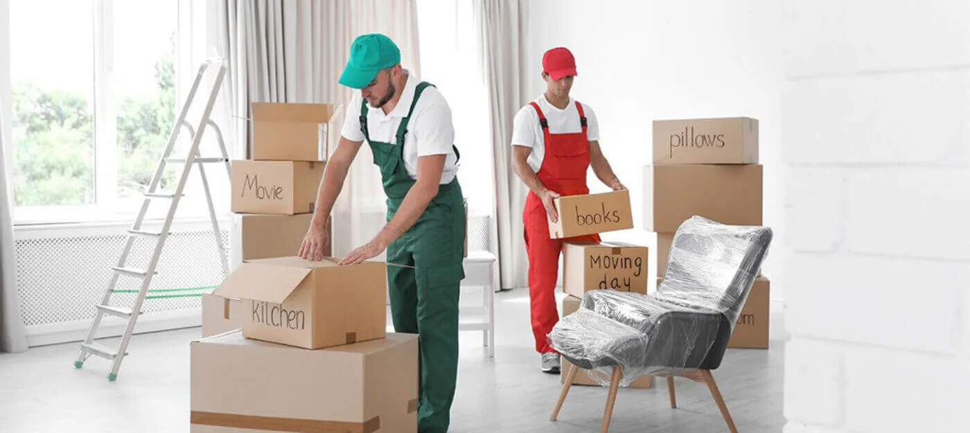 A removal team worker arranging and packing goods in boxes and labeling them accordingly